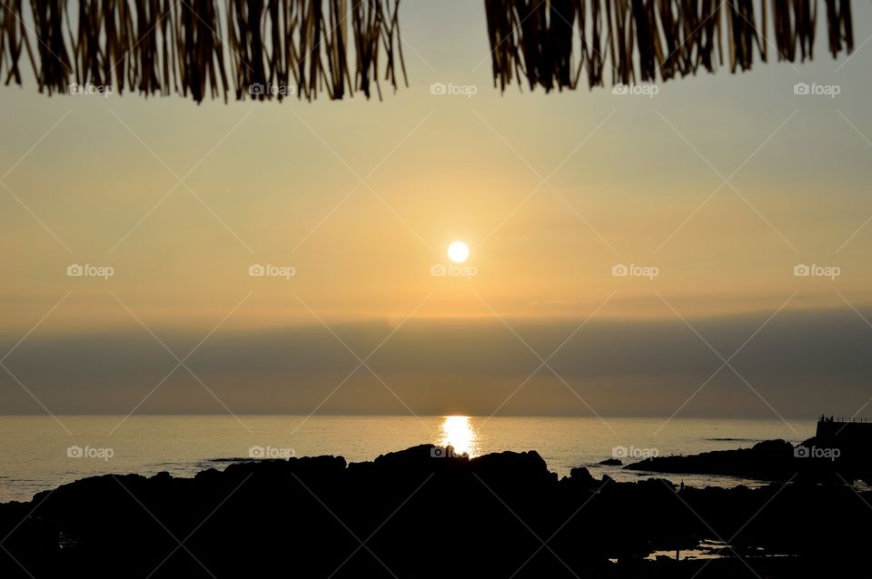 silhouette of a beach umbrella at sunset