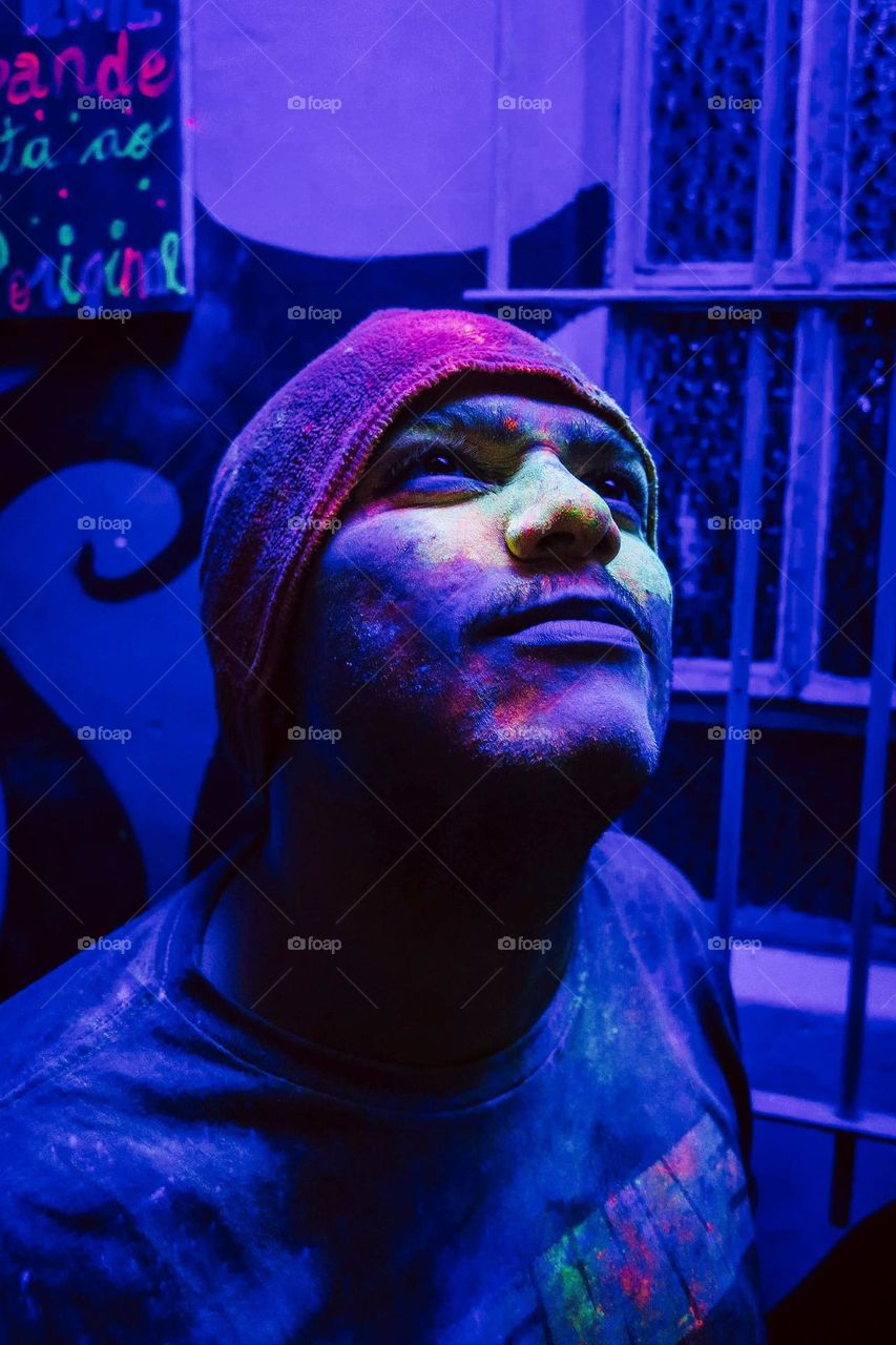 Beautiful Colorful Portrait of a man, with a black light and neon colors. Close up blue portrait