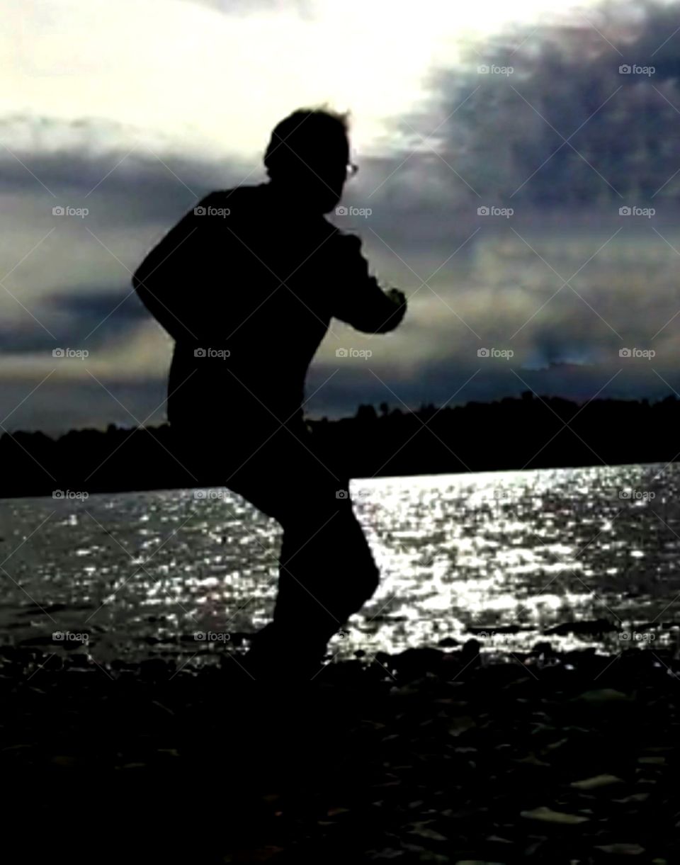 Amazing silhouette of a man at the water