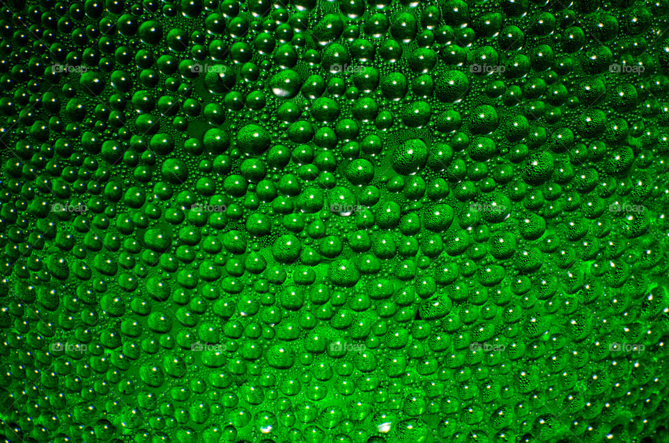 Uneven surfaces background. A drop of water on green container then a similar surface roughness.