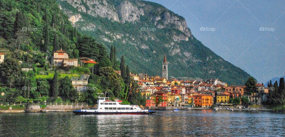 Ferry boat on lake Como. A white Ferry boat glides along The waters of lake Como with the buildings of Bellagio dotting the Alpine mountainside