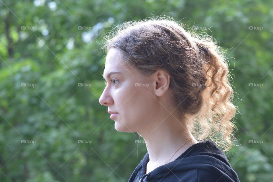 brunette girl beautiful profile portrait outdoor green background