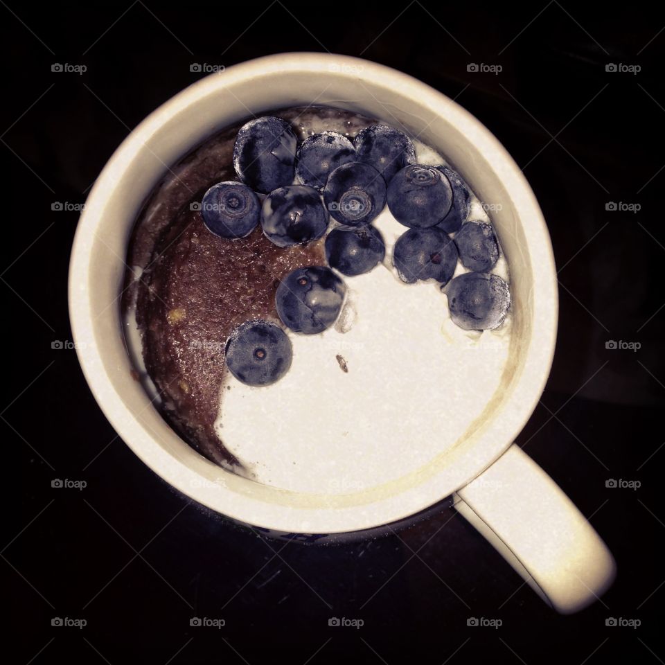 Mug cake. Chocolate mug cake with blueberries and whipped cream