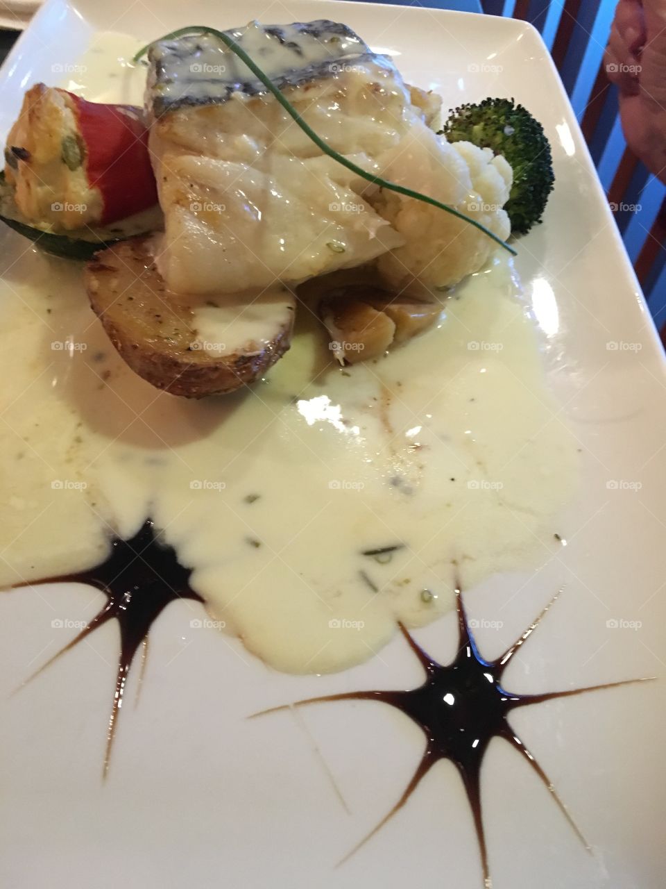 Baked cod with potato and broccoli in a champagne sauce.
