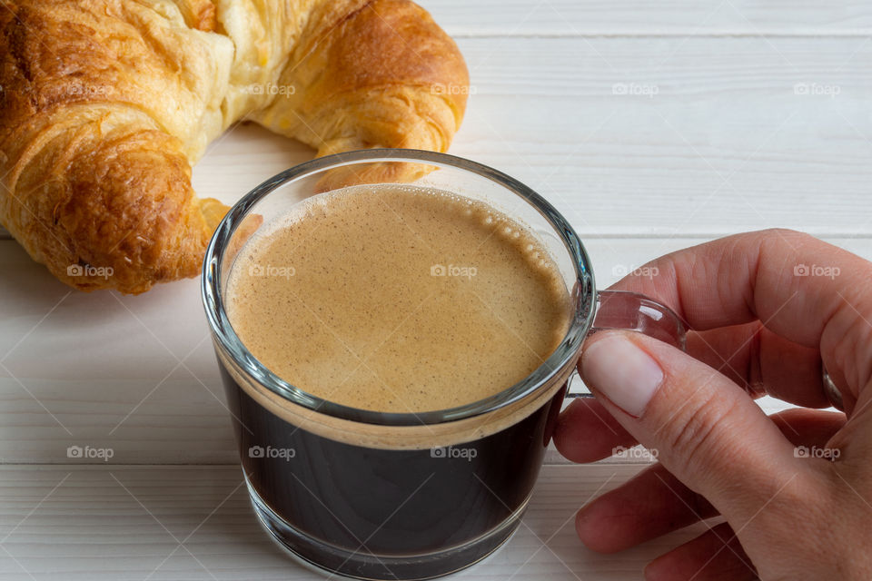 hand holding glass of coffee
