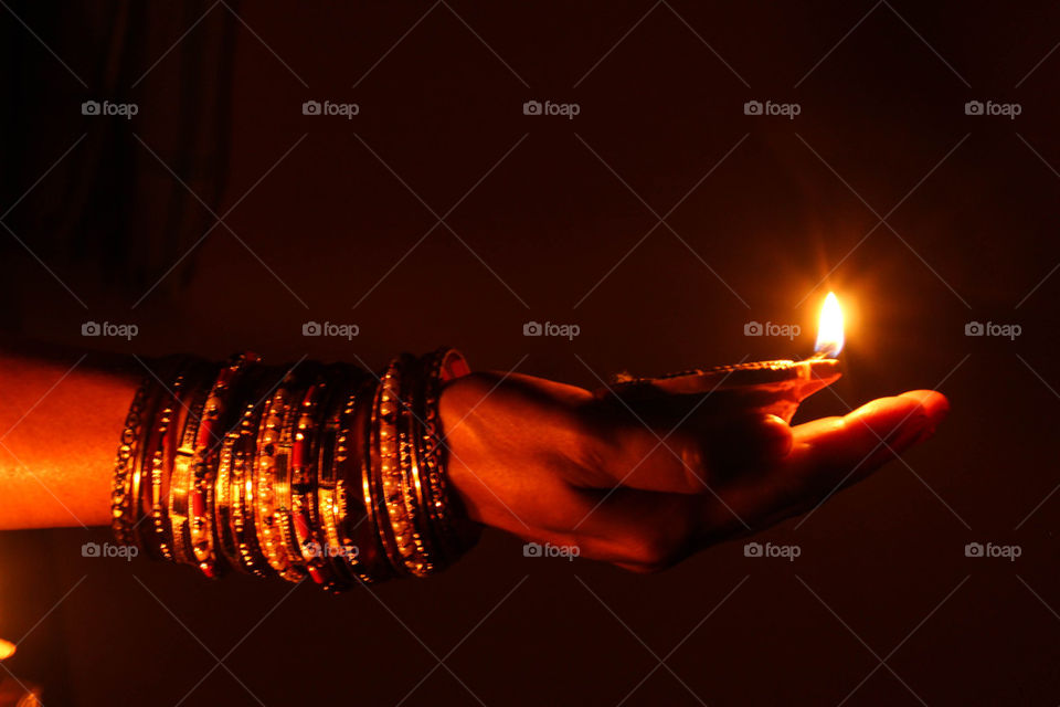 Woman hand holding diwali diya