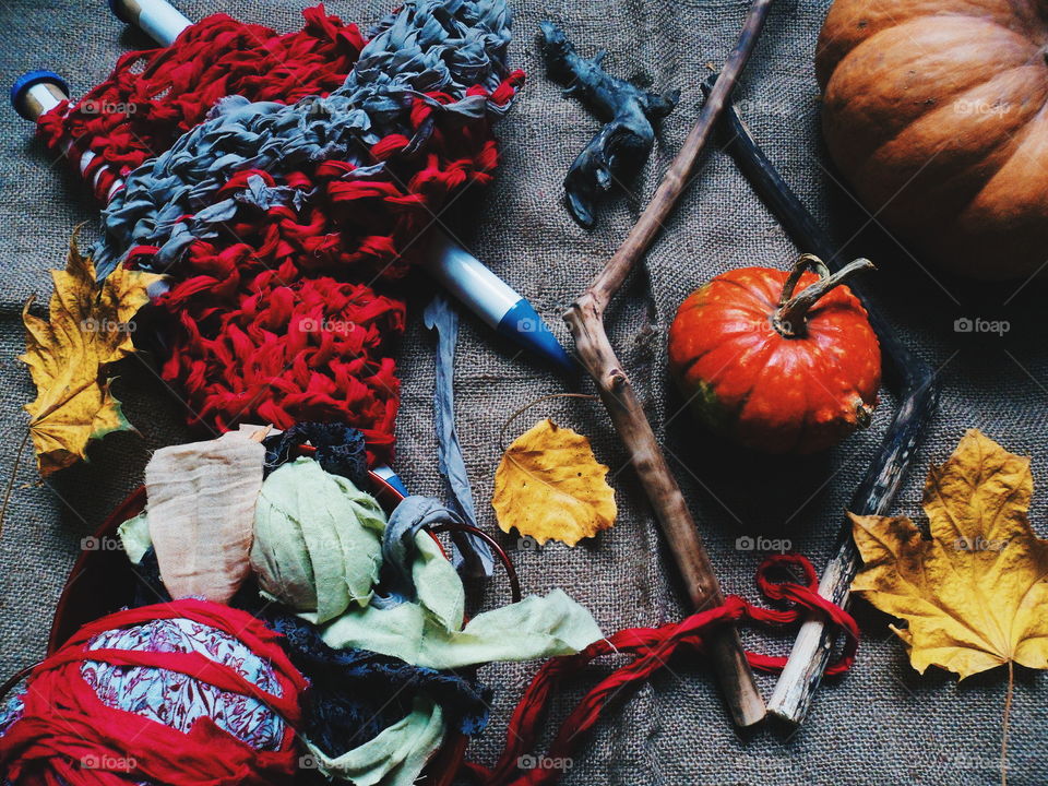 pumpkin, autumn leaves and knitting on the table