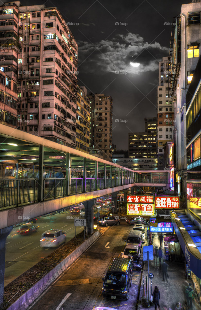 Monkey moon. Moon over Mongkok tenements with shops and pedestrian walkway 