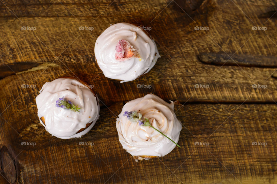 Homemade autumn cupcakes with edible flowers design and lavender chocolate buttercream on rustic wood or table 