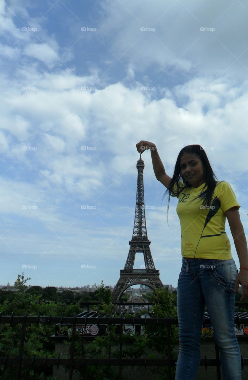 Young woman holding Eiffel Tower in the city