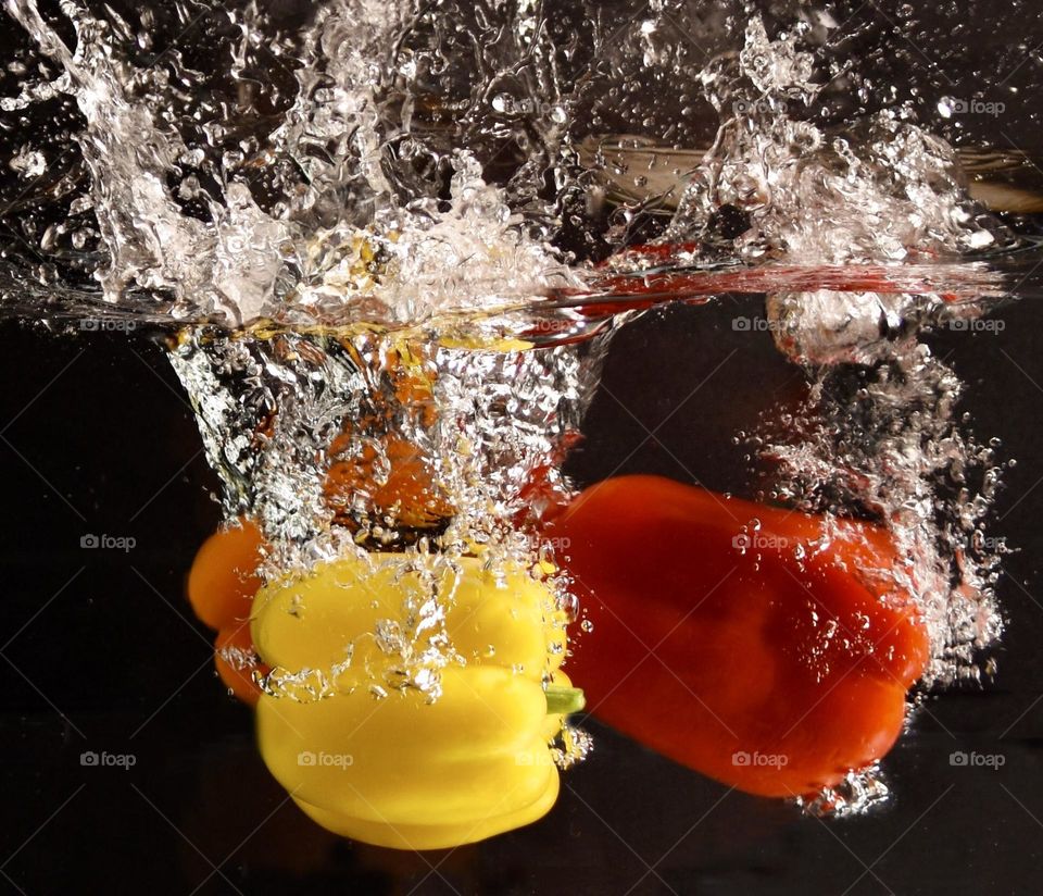 Yellow, orange, and red bell peppers water splash