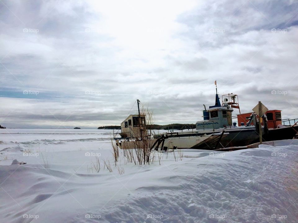 Boat surrounded by vast ocean of snow in Fort Chipewyan during the winter months, Alberta, Canada 