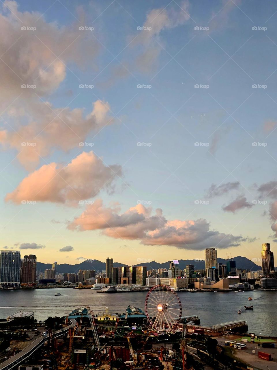 Summer in the city, watching sunset over the city pier, harbour, with ferry and boats