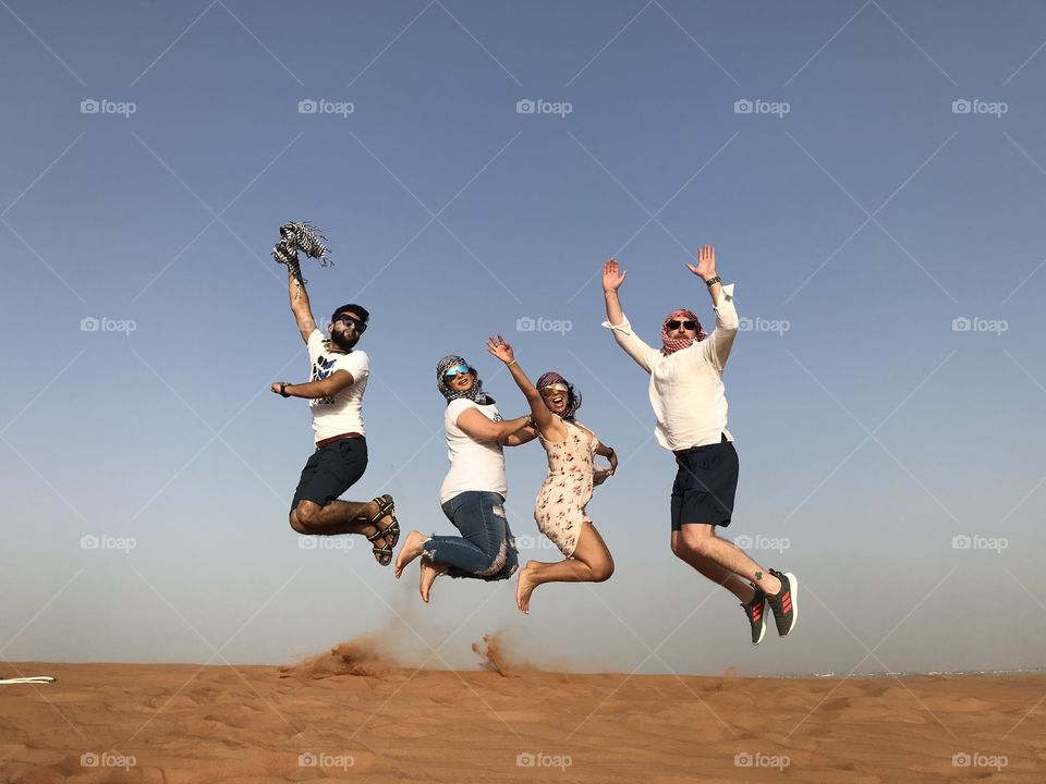 Jump into Adventure! Desert safari in Dubai, United Emirates. Fun, jumping, friends, laughter, splash, active, fitness, sunglasses, diversity, countries, travel, United,