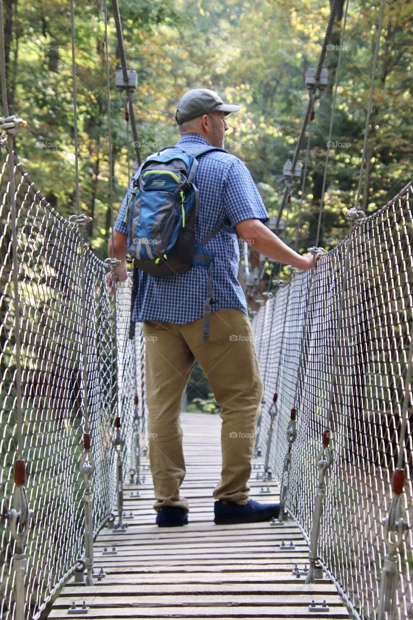 Man hiking across bridge in Ohio, USA