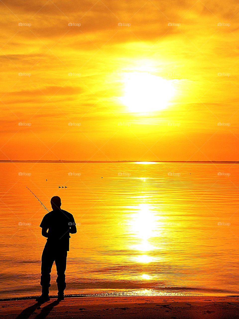 Silhouette of a fisherman during a sunset on the Gulf of Mexico - If you are in a beautiful place where you can enjoy the sunset and fish, then you are living like a king or queen