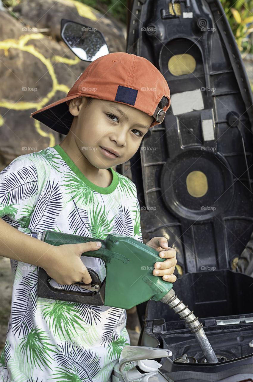 Asian boy filling up fuel into the motorbike