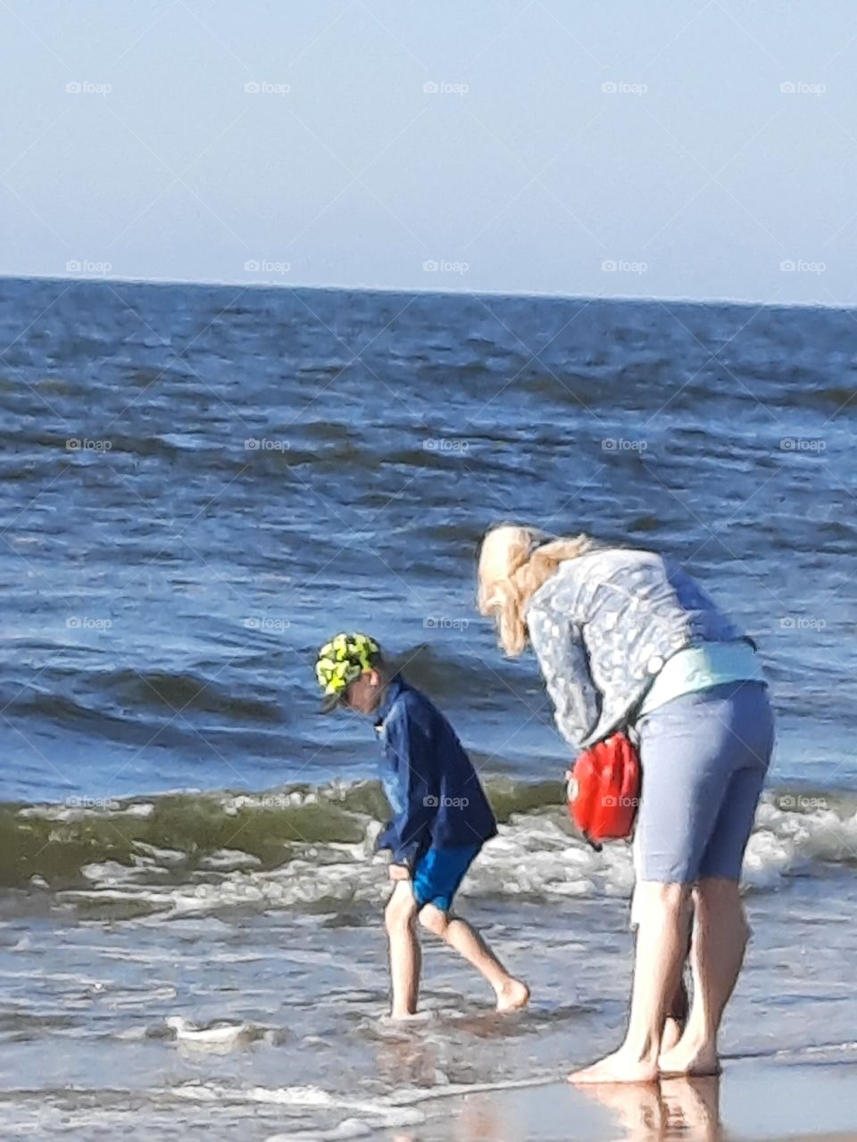 little boy playing with sea waves