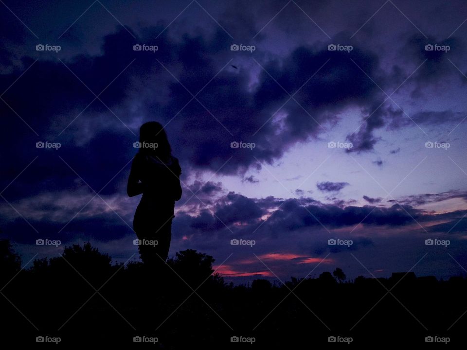 Woman silhouette on the sky background