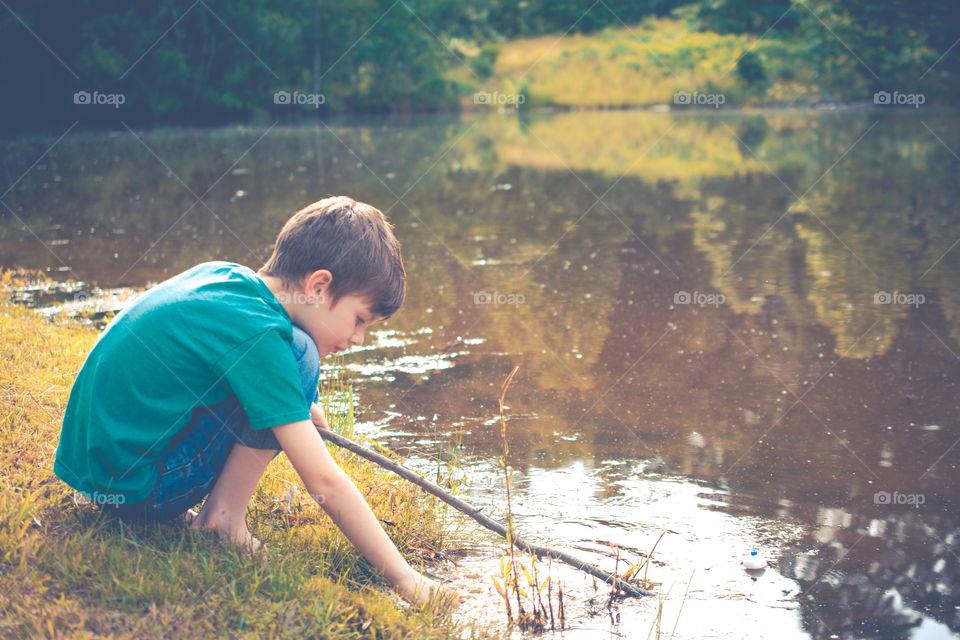 Young Boy Fishing in a Pond with Homemade Pole 3