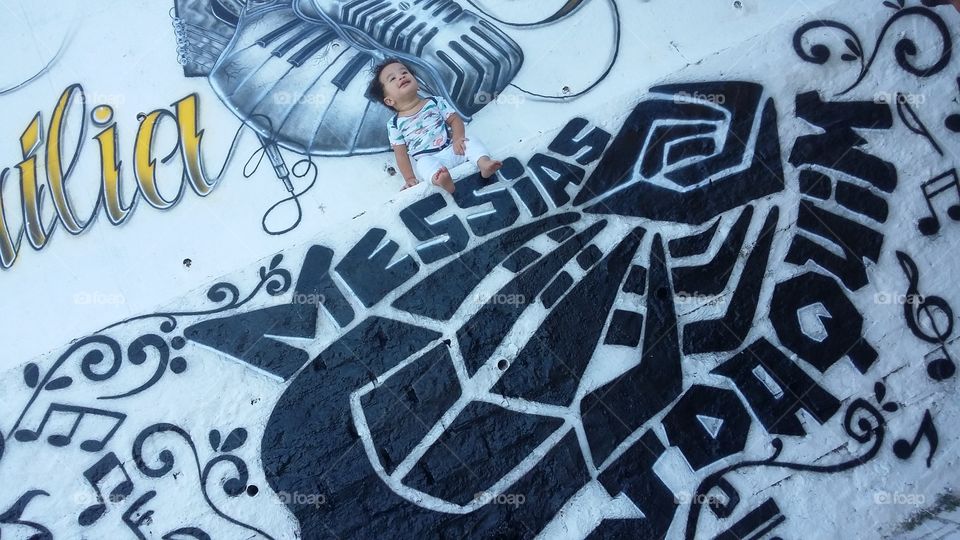 O bebê no muro grafitado. Bebê e arte!
