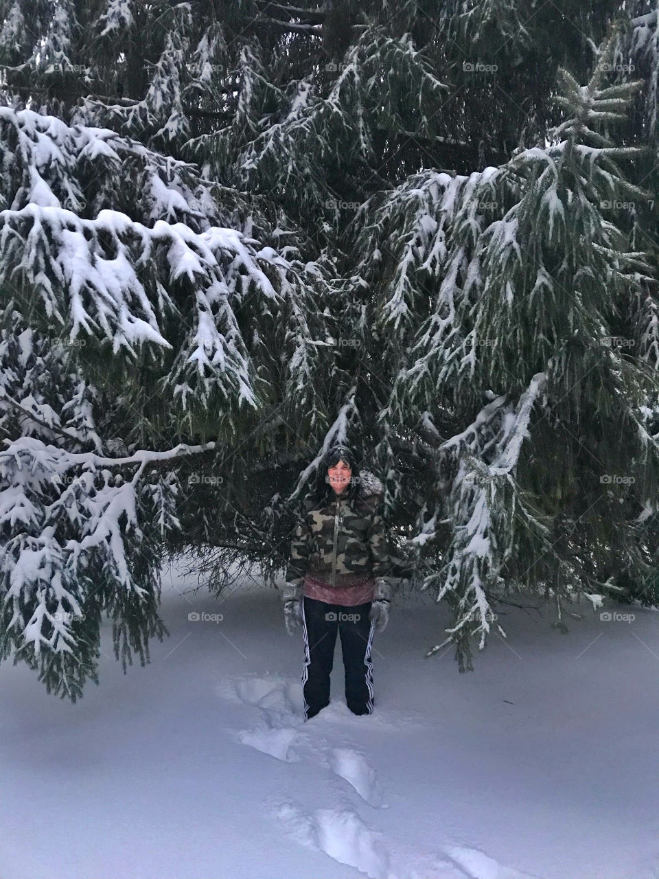 My mom standing in the backyard under our big tree 