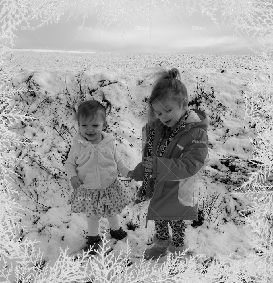 Smiling sisters standing in snow