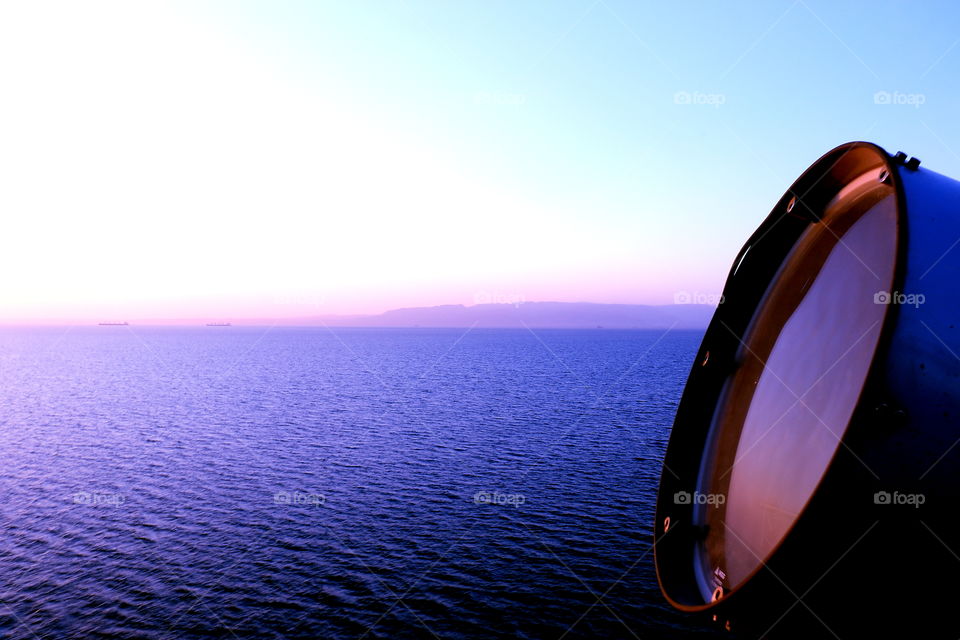 view of blue sea turning purple during sunset captured from the ship