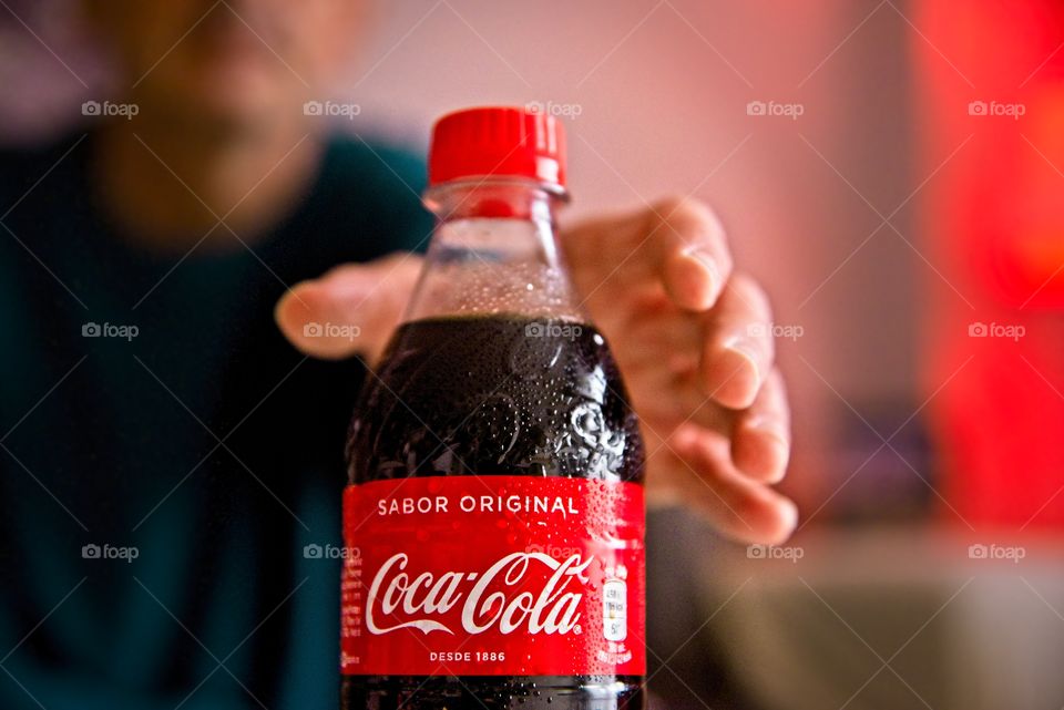 Man taking a bottle of Coca Cola in the living room