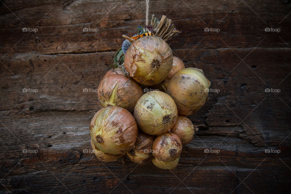 onion bulbs hanging in front of a barn
