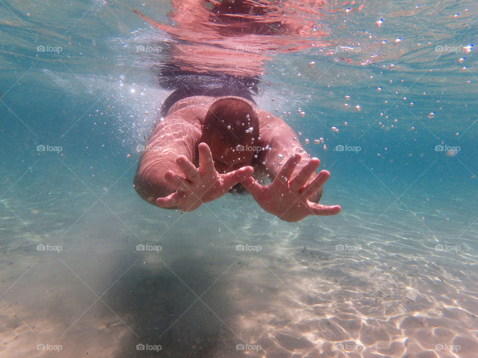 male diver underwater. man diving underwater in clean sea