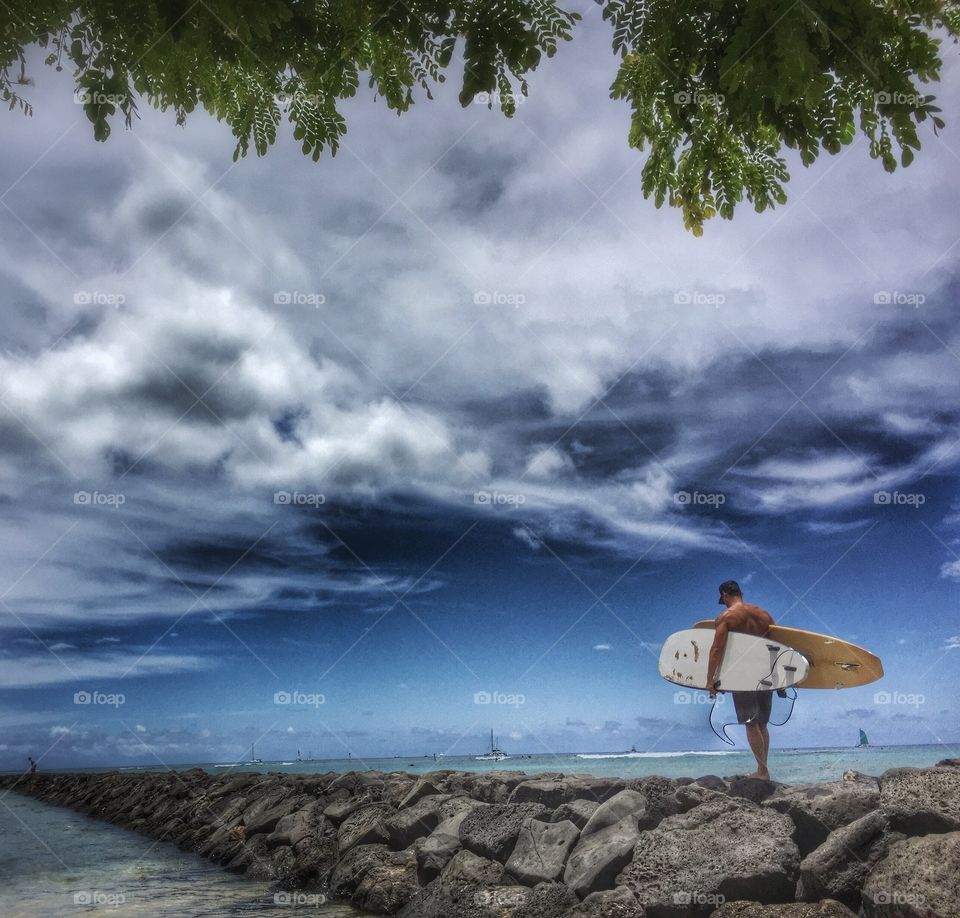 Carrying surf boards on stone jetty