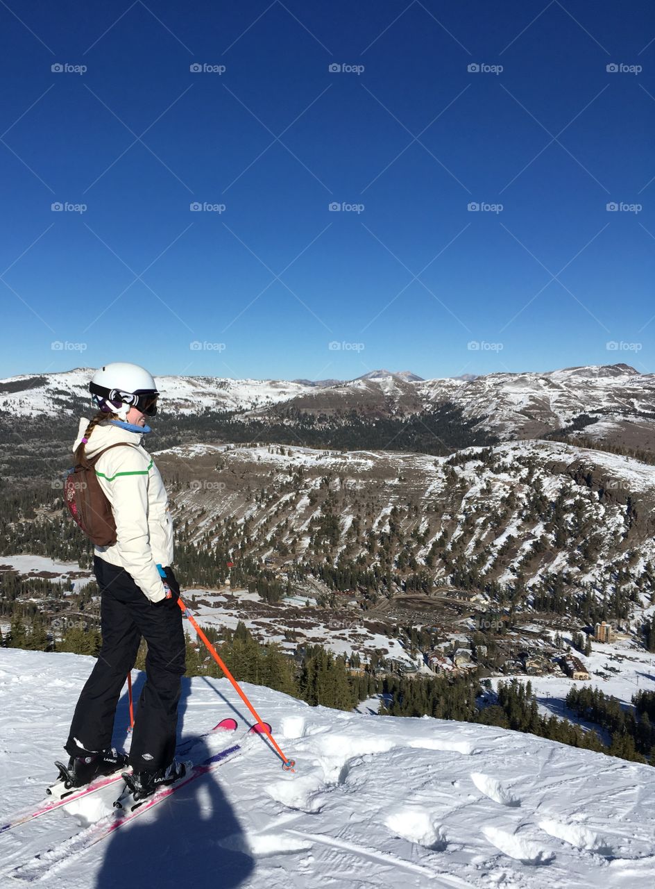 Woman skier at the top of a snow covered mountain