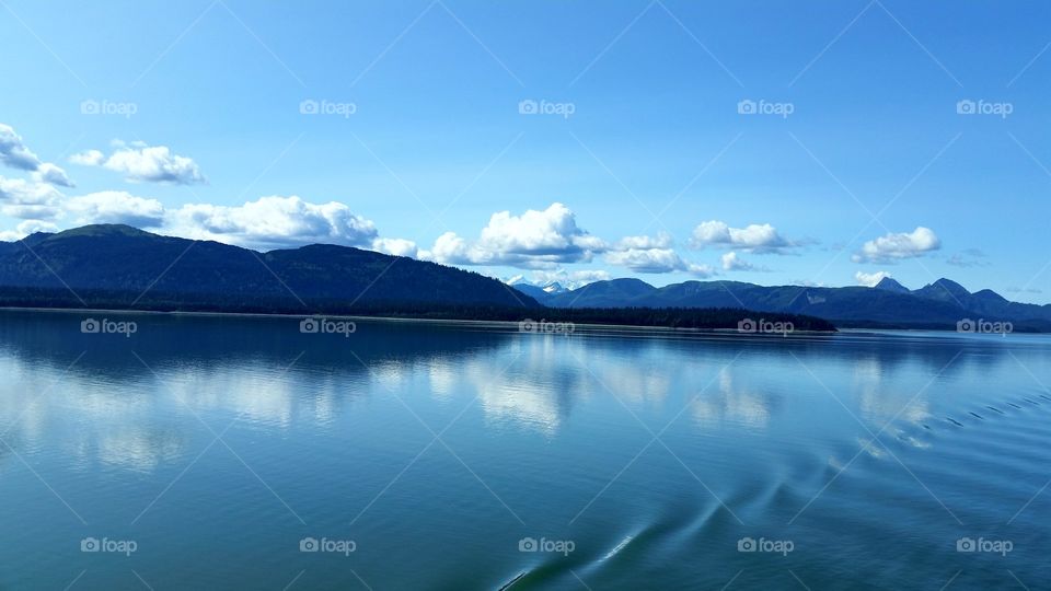 Refection of mountain and clouds on sea