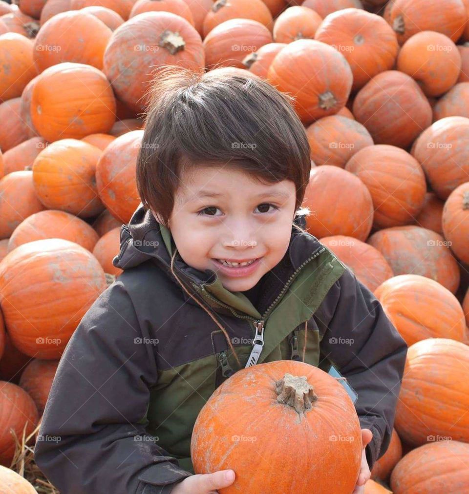 pumpkin patch. my son in a pile of pumpkins