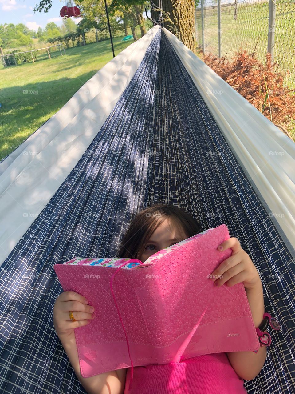 Child reading in a hammock