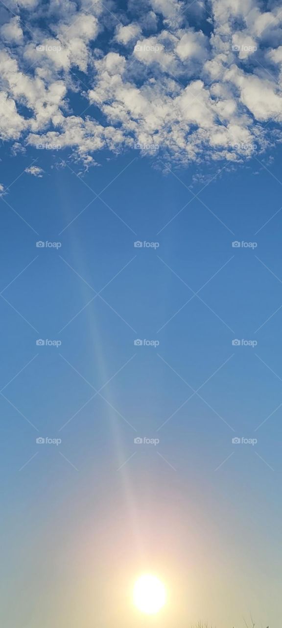 It is a beautiful sunny day with pillow clouds