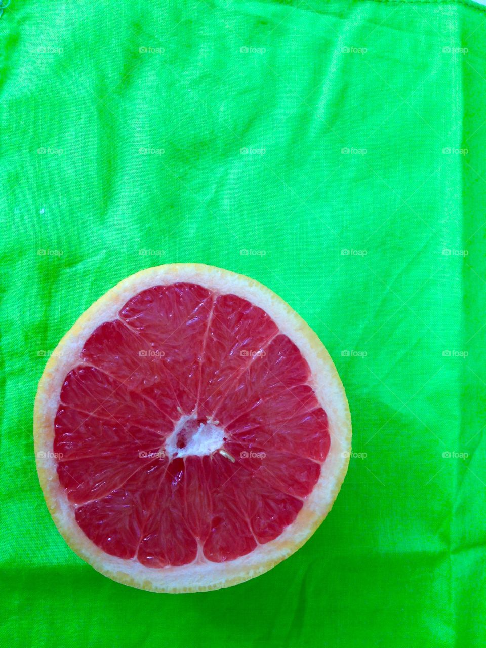 Red grapefruit on green napkin.