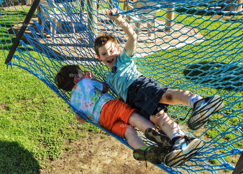 Young Boys Swinging In A Hammock. Brotherly Love
