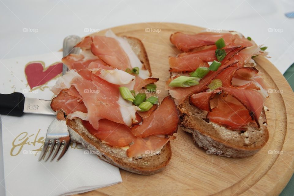 Tasty meal with black bread, butter and speck