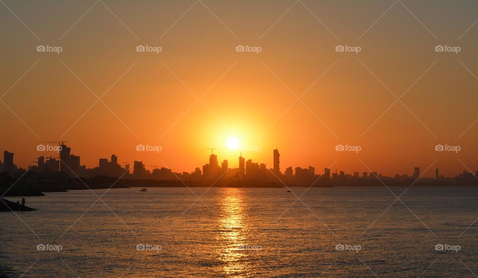 amazing claimet sunset orange colour Kuwait sea side view with buildings for relaxation time.