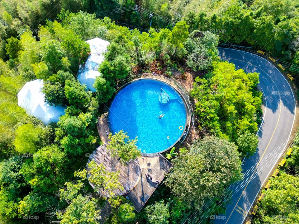 A swimming pool is hidden within a mountain villa, radiating a summertime aura