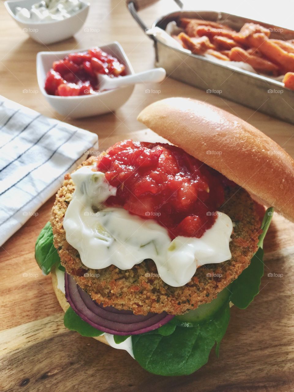 Spicy bean burger with tomato relish and sour cream served with sweet potato fries 🍟🍔