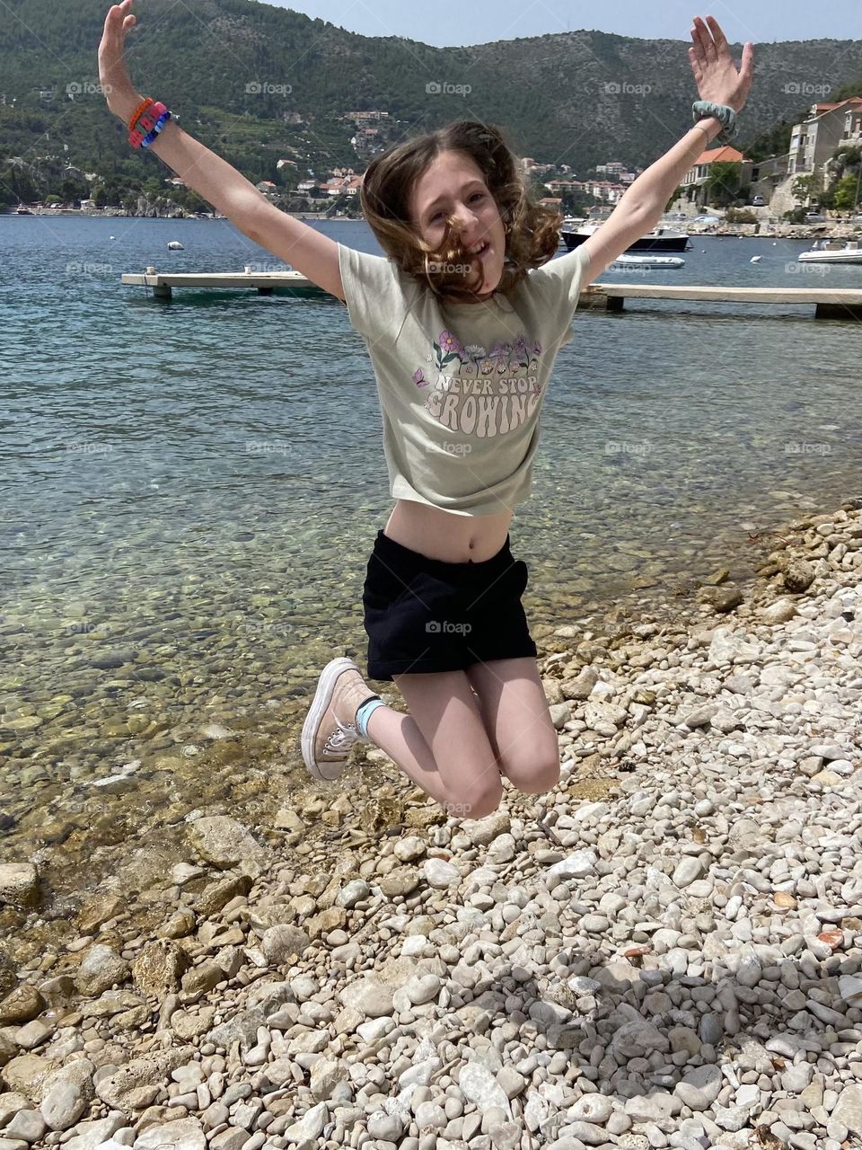 Girl jumping for joy over the last day of school and first day of summer.