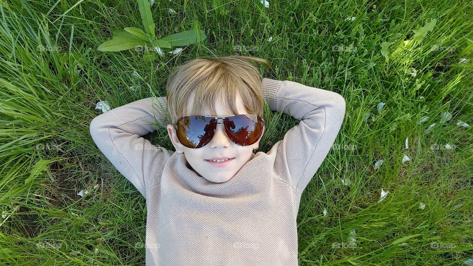 little boy wearing sunglasses on the grass