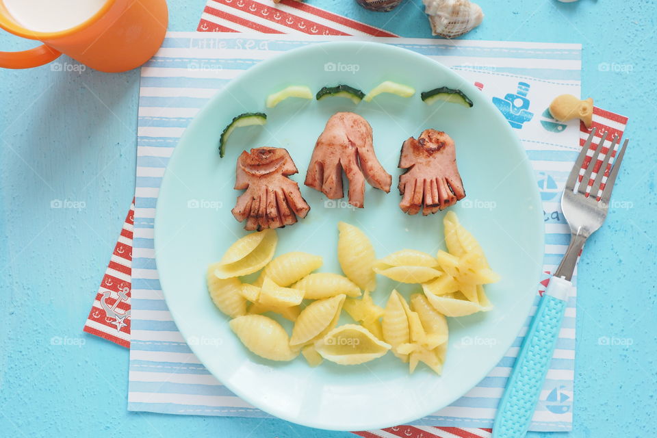 children's serving in a nautical style. octopus sausages and seashell pasta on a plate.