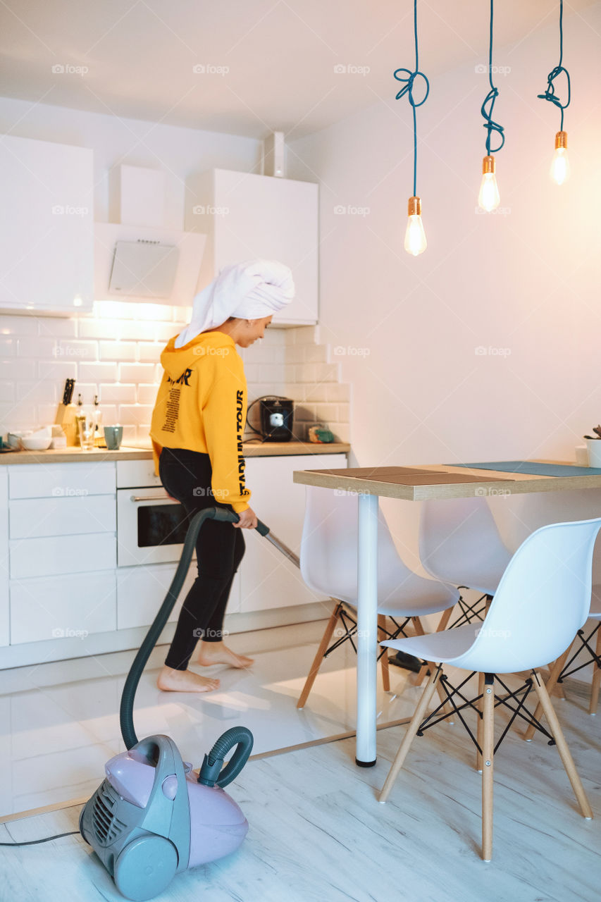 A girl vacuuming a floor at home