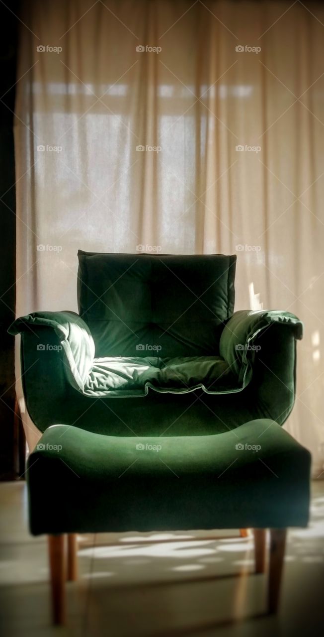 green armchair and white curtain