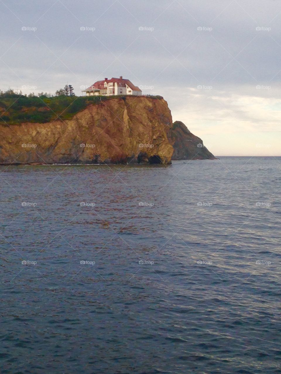 Historic red home on the shore in Perce. 