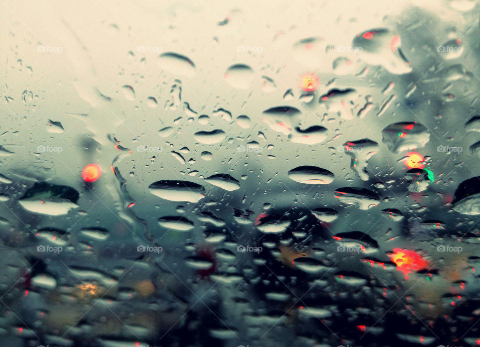 perfect rain drops on the glass of the car and traffic lights. abstract art